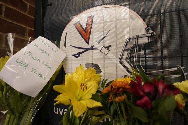 Memorial flowers and notes line walkway at Scott Stadium after three football players were killed in a shooting on the grounds of the University of Virginia Tuesday Nov. 15, 2022, in Charlottesville. Va. (AP Photo/Steve Helber)