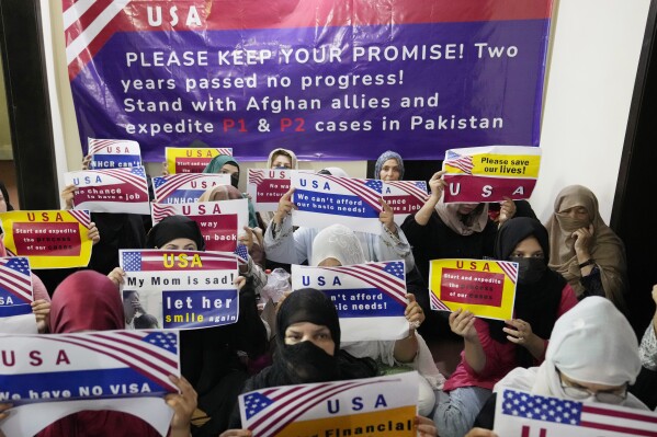 FILE - Afghan refugees hold placards during a gathering in Islamabad, Pakistan, on July 21, 2023. A group of former U.S. diplomats and representatives of resettlement organizations on Wednesday, Oct. 18, asked, in an open letter, Pakistan not to deport thousands of Afghans who have been waiting for U.S. visas under an American program that relocates at-risk Afghan refugees fleeing Taliban rule. (AP Photo/Rahmat Gul, File)