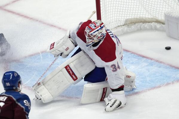 Colorado Avalanche right wing Mikko Rantanen, left, looks on his shot goes in for a score past Montreal Canadiens goaltender Jake Allen in overtime of an NHL hockey game Wednesday, Dec. 21, 2022, in Denver. (AP Photo/David Zalubowski)