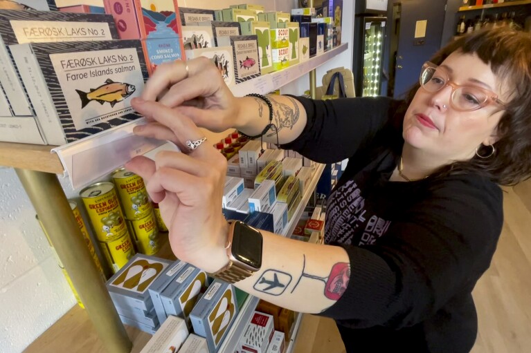 DECANTsf co-founder Cara Patricia restocks shelves of tinned fish inside the bar, Friday, Oct. 13, 2023, in San Francisco. (AP Photo/Haven Daley)