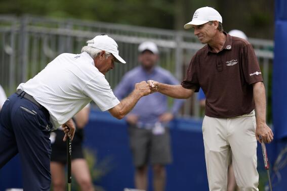 Fred Couples fist bumps Steven Alker, of New Zealand, right, after making his putt on the 18th green during the second round of the PGA Tour Champions Principal Charity Classic golf tournament, Saturday, June 4, 2022, in Des Moines, Iowa. (AP Photo/Charlie Neibergall)