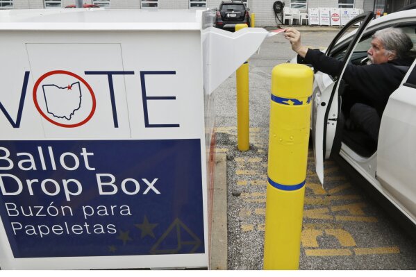 In this April 22, 2020, photo, Jim O'Bryan drops his election ballot in the drop box at the Cuyahoga County Board of Elections in Cleveland. Ohio’s primary will be the nation’s first major test of an almost completely vote-by-mail election. The Tuesday primary also could provide a preview of a November election that might still be marred by the coronavirus outbreak. Joe Biden has all but locked up the Democratic presidential nomination since the state's March 17 primary was delayed. (AP Photo/Tony Dejak, File)