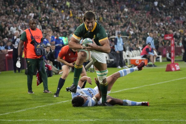 South Africa's Eben Etzebeth, front, scores a try as he leaps over Argentina's Santiago Carreras during the Rugby Championship test match between South Africa and Argentina at Ellis Park stadium in Johannesburg , South Africa, Saturday, July 29, 2023. (AP Photo/Themba Hadebe)
