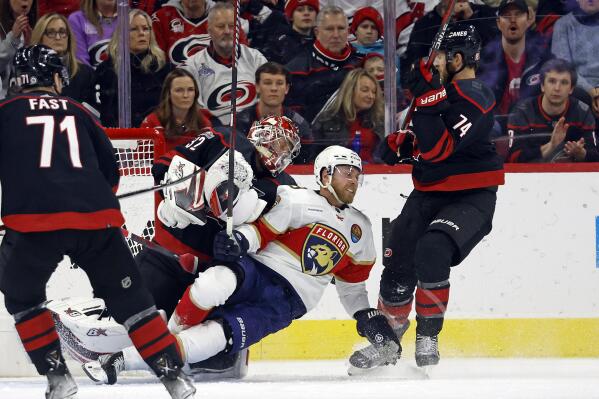Florida Panthers' Sam Bennett (9) collides with Carolina Hurricanes goaltender Antti Raanta (32) with Hurricanes' Jaccob Slavin (74) nearby during the second period of an NHL hockey game in Raleigh, N.C., Friday, Dec. 30, 2022. (AP Photo/Karl B DeBlaker)