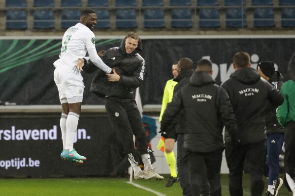 Maccabi Haifa's Frantzdy Pierrot, left, celebrates after scoring his side's opening goal during the Europa Conference League play off second leg soccer match between Gent and Maccabi Haifa at the KAA Gent Arena in Ghent, Belgium, Wednesday, Feb. 21, 2024. (APPhoto/Geert Vanden Wijngaert)