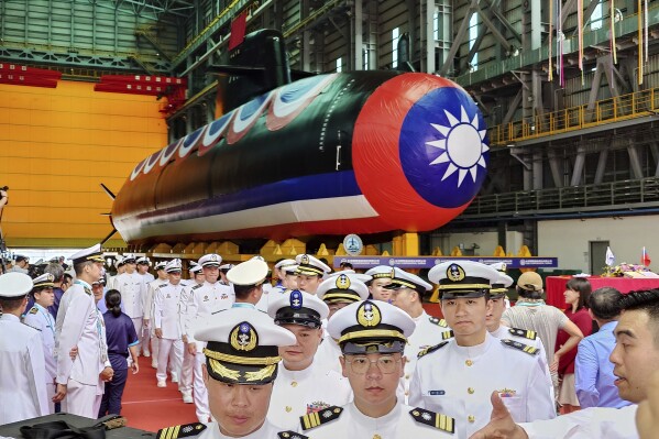 A group of navy personnel pass through Taiwan's domestically-made submarine during the naming and launching ceremony of domestically-made submarines at CSBC Corp's shipyards in Kaohsiung, Southern Taiwan, Thursday, Sept. 28, 2023. Taiwan's first domestically made submarine prototype starts underwater testing. (AP Photo/Chiang Ying-ying)