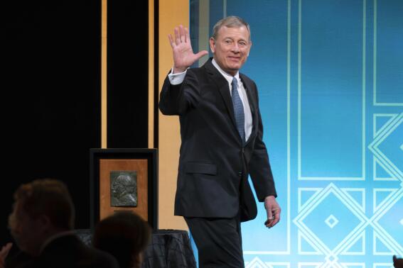 Supreme Court Chief Justice John Roberts waves to the crowd after he received the Henry J. Friendly Medal during the American Law Institute's annual dinner in Washington, Tuesday, May 23, 2023. (AP Photo/Jose Luis Magana)