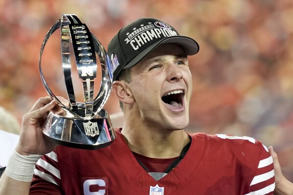 San Francisco 49ers quarterback Brock Purdy celebrates with the trophy after their win against the Detroit Lions in the NFC Championship NFL football game in Santa Clara, Calif., Sunday, Jan. 28, 2024. (AP Photo/David J. Phillip)