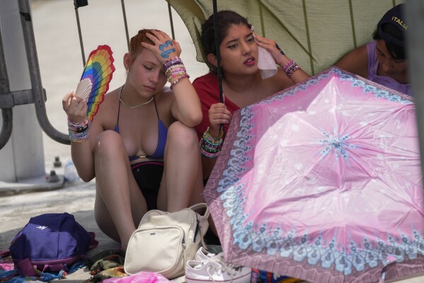 FILE - Taylor Swift fans wait for the doors of the Nilton Santos Olympic stadium to open amid a heat wave in Rio de Janeiro, Brazil, Nov. 18, 2023. A stifling heat wave was sweeping across southeast Brazil the day of Swift’s concert last November, just before the start of summer in the Southern Hemisphere. (AP Photo/Silvia Izquierdo, File)