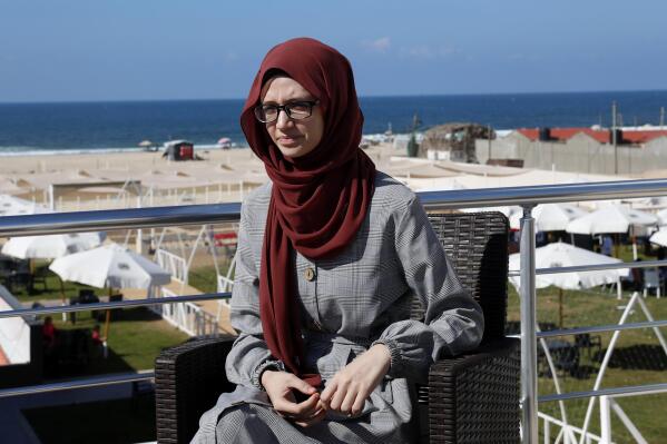 Palestinian student Afaf al-Najar, speaks during an interview at the seaside beach restaurant in Gaza City, Wednesday, Nov. 3, 2021. Al-Najar is fighting to travel out of the Palestinian enclave to Turkey, where she has won a scholarship, but her father banned her, taking advantage of a new Hamas ruling that bars women from traveling against the will of their male "guardians.".(AP Photo/Adel Hana)