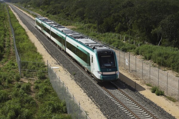The inaugural train with President Andrés Manuel López Obrador on board passes near Chochola, Quintana Roo State, Mexico, Friday, Dec. 15, 2023. Mexico's president inaugurated a 290-mile (473-kilometer) stretch between the colonial Gulf coast city of Campeche and the Caribbean coast resort of Cancun. (AP Photo/Martin Zetina)