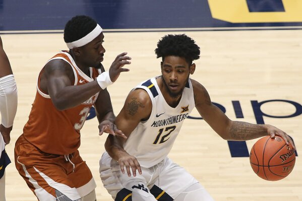 West Virginia guard Taz Sherman (12) is defended by Texas guard Courtney Ramey (3) during the first half of an NCAA college basketball game Saturday, Jan. 9, 2021, in Morgantown, W.Va. (AP Photo/Kathleen Batten)