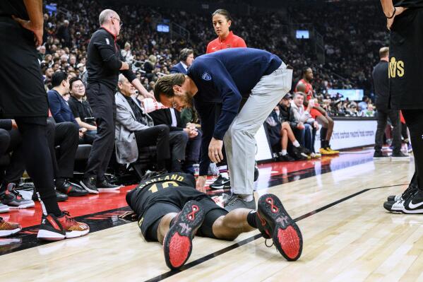 Cleveland Cavaliers guard Darius Garland (10) lies on the court after being injured during the first half of the team's NBA basketball game against the Toronto Raptors on Wednesday, Oct. 19, 2022, in Toronto. (Christopher Katsarov/The Canadian Press via AP)