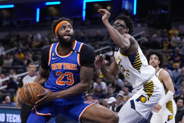 New York Knicks center Mitchell Robinson (23) drives on Indiana Pacers forward Serge Ibaka (25) during the first half of an NBA basketball game in Indianapolis, Wednesday, April 5, 2023. (AP Photo/Michael Conroy)