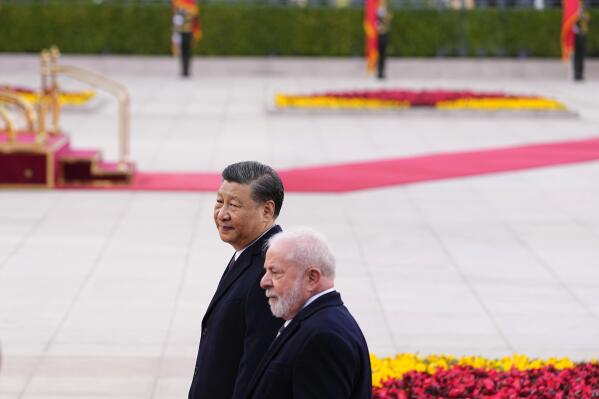 Brazilian President Luiz Inacio Lula da Silva, right, and Chinese President Xi Jinping walk during a welcome ceremony outside the Great Hall of the People in Beijing Friday, April 14, 2023. (Ken Ishii/Pool Photo via AP)