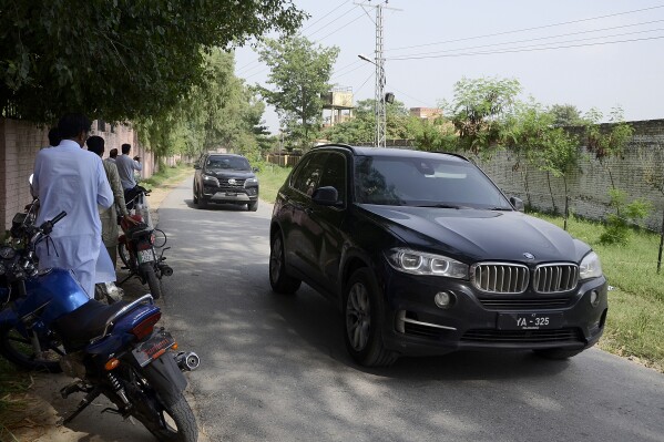 Members of media film a vehicle carrying Bushra Bibi, wife of Pakistan's imprisoned former Prime Minister Imran Khan, driving towards the district prison, in Attock, Pakistan, Thursday, Aug. 10, 2023. Pakistan's imprisoned former Prime Minister Khan was allowed a brief visit by his wife on Thursday at a high-security prison where the top opposition leader and national cricket hero is being held, his lawyer said. (AP Photo/Ghulam Shabbir)