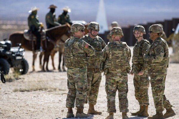 Army soldiers chat while waiting the arrival of Defense Secretary Pete Hegseth to the US-Mexico border in Sunland Park, N.M., Monday, Feb. 3, 2025. (AP Photo/Andres Leighton, File)