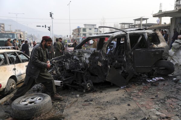 People gather near the site of a deadly bombing attack in Kabul, Afghanistan, Sunday, Dec. 20, 2020. Afghanistan's Interior Ministry says that the car bomb blast killed at least eight people and wo...