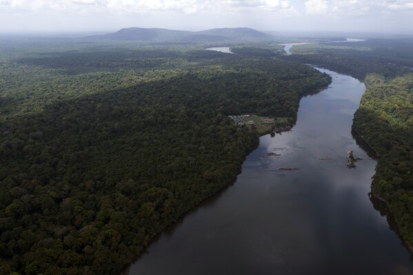 FILE - The Essequibo River flows through Kurupukari crossing in Guyana, Nov. 19, 2023. Venezuela has long claimed Guyana's Essequibo region, a territory larger than Greece and rich in oil and minerals. On Sunday, Dec. 10, the government of Guyana, under pressure from neighboring Brazil and a Caribbean trading bloc, agreed to join bilateral talks with Venezuela over an escalating territorial dispute. (AP Photo/Juan Pablo Arraez, File)