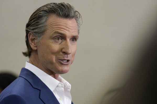 FILE - California Gov. Gavin Newsom speaks at a news conference in Sacramento, Calif., on March 16, 2023. Newsom had threatened to fine the Temecula Valley Unified School District for not approving a social studies curriculum for elementary school students. The board approved the curriculum in a special meeting on Friday, July 21. Board President Joseph Komrosky said the vote was not in response to Newsom's threat. He said it was to avoid a potential lawsuit. (AP Photo/Rich Pedroncelli, File)