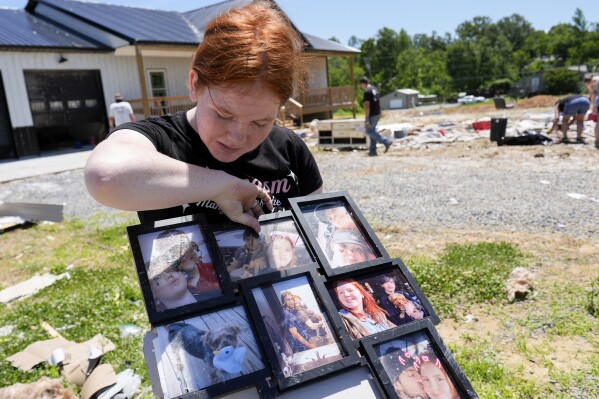Haley Loukota, looks over family photographs found among storm debris from her demolished home along Barnsley Loop, Tuesday, May 28, 2024, in Madisonville, Ky. A series of powerful storms hit the central and southern U.S. over the Memorial Day holiday weekend. (AP Photo/George Walker IV)