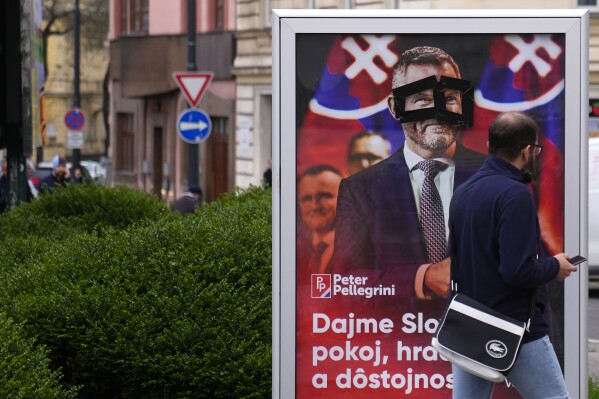 A man walks past a poster for Peter Pellegrini, who currently serves as Parliament's speaker, one of the nine candidates in the upcoming Slovakia's presidential election, Bratislava, Slovakia, Friday, March 22, 2024. (AP Photo/Petr David Josek)