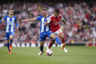 Brighton's Alexis Mac Allister, left, challenges for the ball with Arsenal's Reiss Nelson during the English Premier League soccer match between Arsenal and Brighton and Hove Albion at Emirates stadium in London, Sunday, May 14, 2023. (AP Photo/Kirsty Wigglesworth)