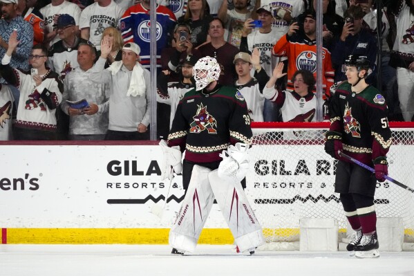Arizona Coyotes goaltender Connor Ingram (39) and defenseman Vladislav Kolyachonok, right, watch the movement of the puck as time expires during the third period of the team's NHL hockey game against the Edmonton Oilers Wednesday, April 17, 2024, in Tempe, Ariz. The Coyotes won 5-2. (AP Photo/Ross D. Franklin)
