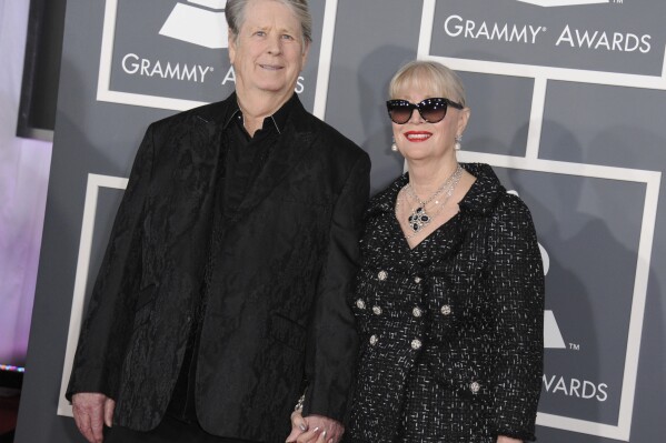 FILE - Musician Brian Wilson, left, and Melinda Ledbetter Wilson arrive at the 55th annual Grammy Awards on Sunday, Feb. 10, 2013, in Los Angeles. Ledbetter Wilson, the longtime wife and manager of Brian Wilson whom the Beach Boys co-founder often credited for stabilizing his famously troubled life, has died at age 77. (Photo by Jordan Strauss/Invision/AP, File)