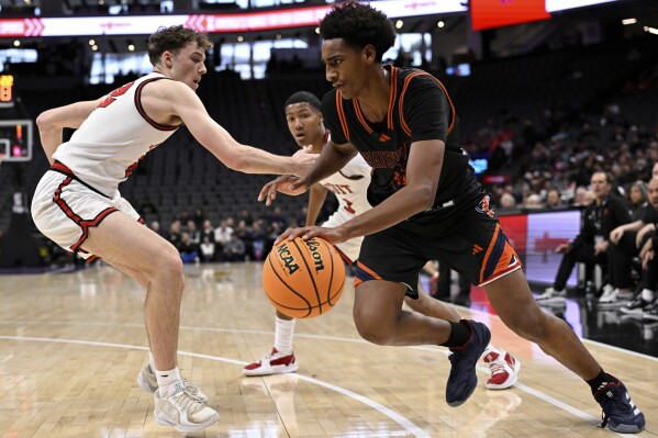 Chatsworth High School basketball player Alijah Arenas, right, is defended by a Jesuit player in the second half of a boys CIF State Division II championship basketball game in Sacramento, Saturday, March 15, 2025. (Keith Birmingham/The Orange County Register via AP)