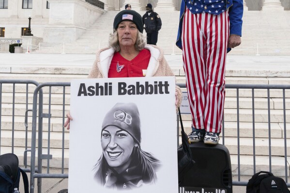 Micki Witthoeft, center, mother of Ashli Babbitt, the woman fatally shot by police inside the U.S. Capitol during the Jan. 6, 2021, riot, joins protesters outside of the Supreme Court on the second anniversary of the Jan. 6, assault on the U.S. Capitol, in Washington, Jan. 6, 2023. (AP Photo/Jose Luis Magana)