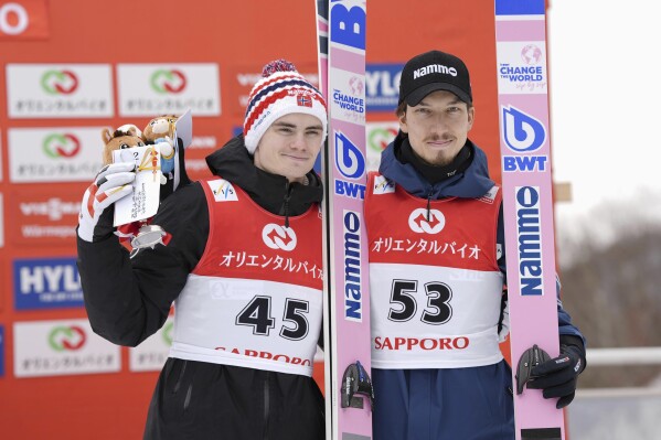 Second placed Marius Lindvik, left, of Norway, and third placed Johann Forfang of Norway pose together on the podium during the men's Ski Jumping World Cup event in Sapporo, northern Japan Sunday, Feb. 16, 2025. (Kyodo News via AP)