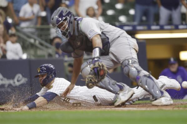 Milwaukee Brewers catcher Manny Pina (9) scores the winning run on a Keston Hiura sacrifice fly against the Colorado Rockies during the 11th inning of a baseball game Friday, June 25, 2021, in Milwaukee. (AP Photo/Jeffrey Phelps)