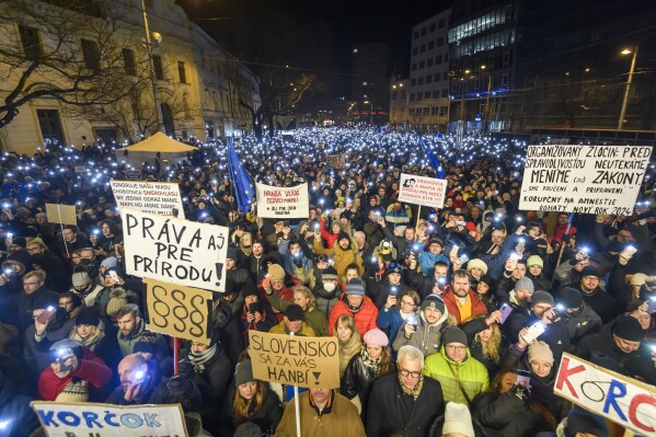 People gather to take part in a protest against a government plan to amend the penal code, in Bratislava, on Thursday, Jan. 11, 2024. Thousands of people have taken to the streets of major cities in Slovakia to renew their protests against plans by the new government of populist Prime Minister Robert Fico to amend the country’s penal code. The changes proposed by the three-party coalition government include a proposal to abolish the special prosecutors’ office which handles serious crimes such as graft, organized crime and extremism. (Jaroslav Novak/TASR via AP)