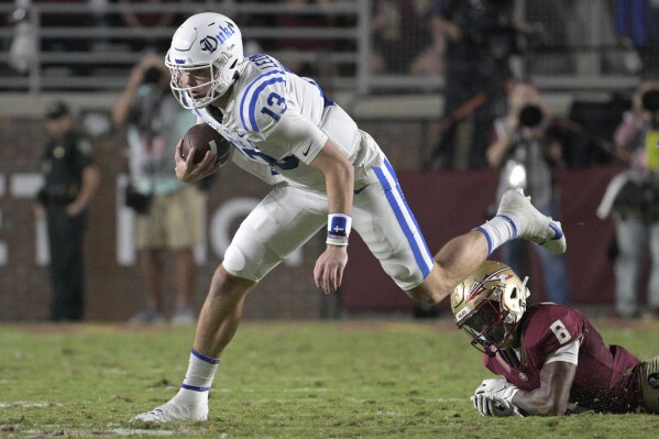 Duke quarterback Riley Leonard (13) scrambles for yardage after breaking free from Florida State defensive back Renardo Green (8) during the first half of an NCAA college football game, Saturday, Oct. 21, 2023, in Tallahassee, Fla. (AP Photo/Phelan M. Ebenhack)