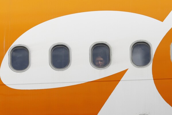 Una persona mira a través de la ventana de un avión que trasladó a migrantes venezolanos deportados desde Estados Unidos, tras aterrizar en el Aeropuerto Internacional Simón Bolívar en Maiquetia, Venezuela, el 24 de febrero de 2025. (AP Foto/Cristian Hernández)