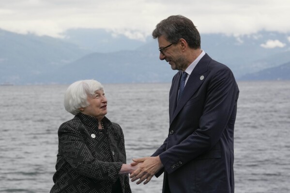 United States' Treasury Secretary Janet Yellen shakes hands with Italy's Finance Minister Giancarlo Giorgetti as she arrives at the G7 Finance Ministers meeting in Stresa, northern Italy, Friday, May 24, 2024. (AP Photo/Antonio Calanni)