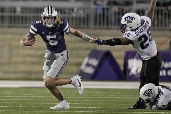 Kansas State quarterback Avery Johnson (5) tries to break away from TCU safety Millard Bradford (28) as he runs the ball during the second half of an NCAA college football game Saturday, Oct. 21, 2023, in Manhattan, Kan. (AP Photo/Charlie Riedel)