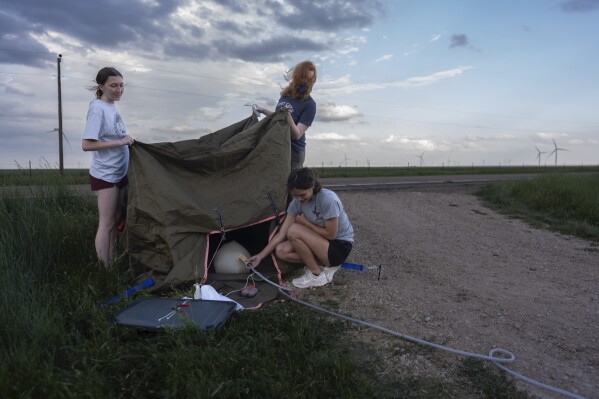 Project ICECHIP members from Northern Illinois University on the black team including Evelynn Mantia, left, and Olivena Carlisle, lower right, inflate a weather balloon with a radiosonde attached to collect data Wednesday, June 4, 2025, in Tucumcari, N.M. (AP Photo/Carolyn Kaster)