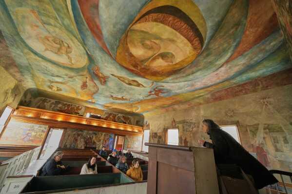 Veronique Plesch, an art professor at Colby College, gives a lecture to art teachers about the frescoes that adorn the walls and ceiling of the South Solon Meeting House, Sunday, April 6, 2025, in Solon, Maine. (AP Photo/Robert F. Bukaty)