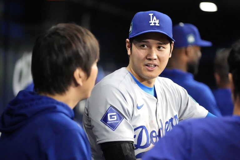 Los Angeles Dodgers designated hitter Shohei Ohtani, right, speaks with interpreter Ippei Mizuhara during the ninth inning of an Opening Day baseball game against the San Diego Padres at the Gocheok Sky Dome in Seoul, Korea of the South, on Wednesday, March 20, 2024, in Seoul.  South Korea.  (AP Photo/Lee ​​Jin-man)