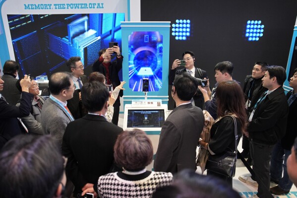 People crowd around an AI Fortune Teller at the SK booth during the CES tech show Wednesday, Jan. 10, 2024, in Las Vegas. (AP Photo/John Locher)