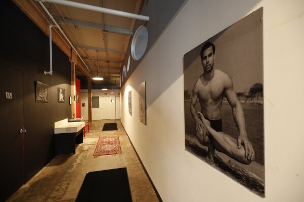 In this April 1, 2020, photo, the long hallway inside Naveed Abidi's Bikram Yoga West is empty, of members after being closed by the city last week, tipped off by several residents who disagreed with it being an essential health and wellness center in Chicago. "It was not like an act of rebellion or anything," said Abidi, who faces a fine of up to $10,000. "If we were naughty with the government's order, then we're very, very sorry. We're not here to cause problems, we're here to practice our poses." (AP Photo/Charles Rex Arbogast)