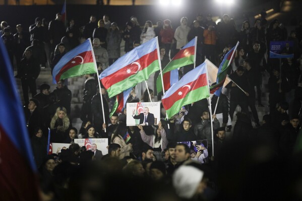 Personas ondean la bandera nacional celebrando la victoria del presidente de Azerbaiyán Ilhan Aliyev en la elección presidencial en Bakú, Azerbaiyán, el miércoles 7 de febrero de 2024. (AP Foto)