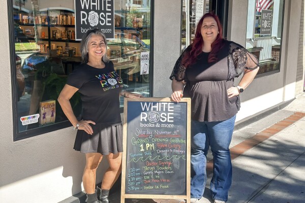 This image released by White Rose Books & More shows bookstore owners Tania Galiñanes, left, and Erin Decker outside their shop in Kissimmee, Fla. on Nov. 4, 2023. (Carlos Galiñanes/White Rose Books & More via AP)