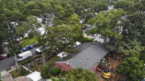 Authorities continue to work at the home of suspect Rex Heuermann, bottom right, in Massapequa Park, N.Y., Monday, July 24, 2023. Heuermann has been charged with killing at least three women in the long-unsolved slayings known as the Gilgo Beach killings. (AP Photo/Seth Wenig)