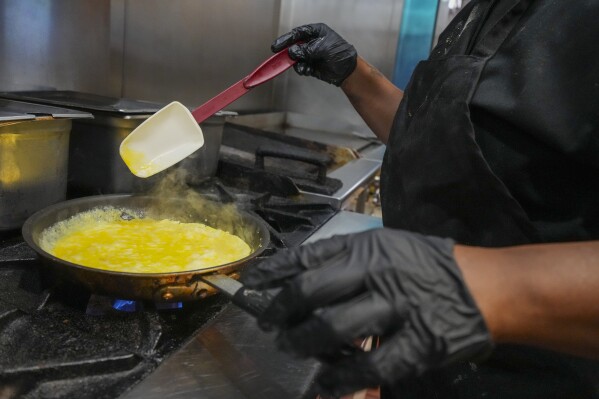Johkiya Pierre prepares a fresh omelette at The Breakfast Brothers restaurant, Wednesday, Feb. 12, 2025, in Arlington, Texas. (AP Photo/Julio Cortez)