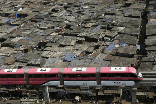 FILE - A Mumbai Monorail train moves past a slum area during a trial run between Wadala and Chembur in Mumbai, India, on Jan. 30, 2014. (Ǻ Photo/Rajanish Kakade, File)