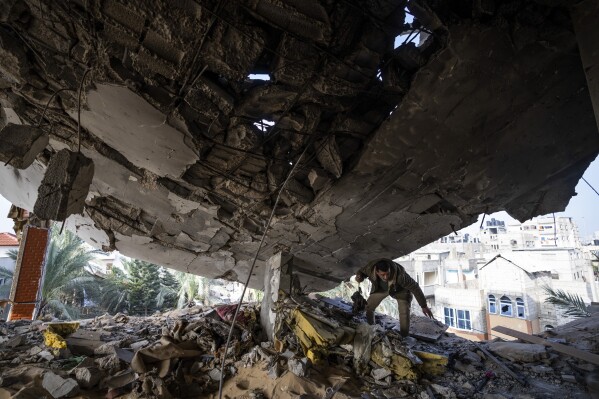 A Palestinian salvages belongings after an Israeli strike in Rafah, Gaza Strip, Saturday, Feb.10, 2024. (AP Photo/Fatima Shbair)