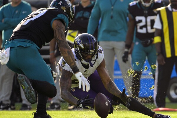 FILE - Baltimore Ravens cornerback Marcus Peters, front right, recovers a fumble thrown by Jacksonville Jaguars quarterback Trevor Lawrence (not shown) during the second half of an NFL football game Nov. 27, 2022, in Jacksonville, Fla. The Las Vegas Raiders have signed two-time All-Pro cornerback Peters in an effort to address one of their most pressing needs. (AP Photo/Phelan M. Ebenhack, File)